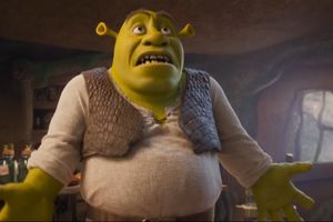 Shrek, zielony ogr z wyrazem zdziwienia, stoi w przytulnym pomieszczeniu.