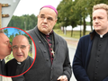 Na zdjęciu widać mężczyzn w duchownych stroju, rozmawiających przy drodze.