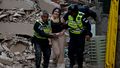 Policjanci ewakuują ranną ofiarę z zawalonego budynku po trzęsieniu ziemi w Caracas
