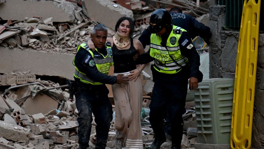 Policjanci ewakuują ranną ofiarę z zawalonego budynku po trzęsieniu ziemi w Caracas