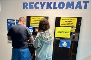 Para ludzi korzysta z recyklo­mat­u z wyraźnymi informacjami o jego nieczynności.
