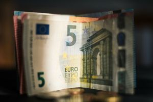 Zdjęcie przedstawia złożony banknot 5 euro z widocznymi detalami architektonicznymi.