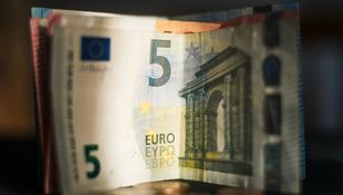 Zdjęcie przedstawia złożony banknot 5 euro z widocznymi detalami architektonicznymi.