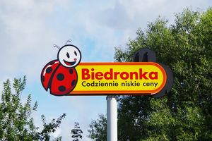 Logo sieci sklepów Biedronka, z uśmiechniętą biedronką i hasłem: 