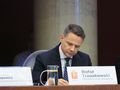 Na zdjęciu Rafał Trzaskowski, prezydent Warszawy, siedzący przy stole, piszący notatki.