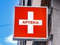 Czerwony szyld z białym krzyżem i napisem 