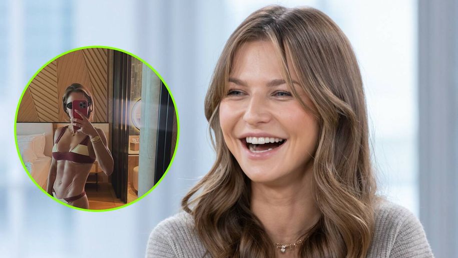 Zadowolona Anna Lewandowska w szarej bluzie, śmieje się do aparatu.