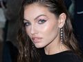Thylane Blondeau w długich, błyszczących kolczykach, z mokrymi włosami i wyrazistym makijażem.