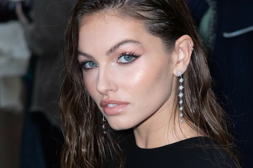 Thylane Blondeau w długich, błyszczących kolczykach, z mokrymi włosami i wyrazistym makijażem.