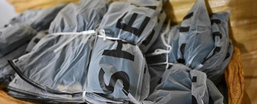 Zestaw zapakowanych elementów w przezroczystych opakowaniach leżących w koszu.