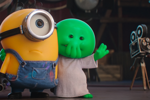 Na zdjęciu dwa kolorowe stworki: żółty minion i zielony potwór w białej szacie na planie filmowym.
