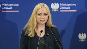 Kobieta z długimi, blond włosami, przemawiająca na konferencji z logo Ministerstwa Zdrowia.