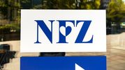 Logo NFZ na ścianie, niebieskie litery na białym tle, z sercem w literze 