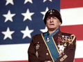 George C. Scott w filmie „Patton” w mundurze na tle amerykańskiej flagi
