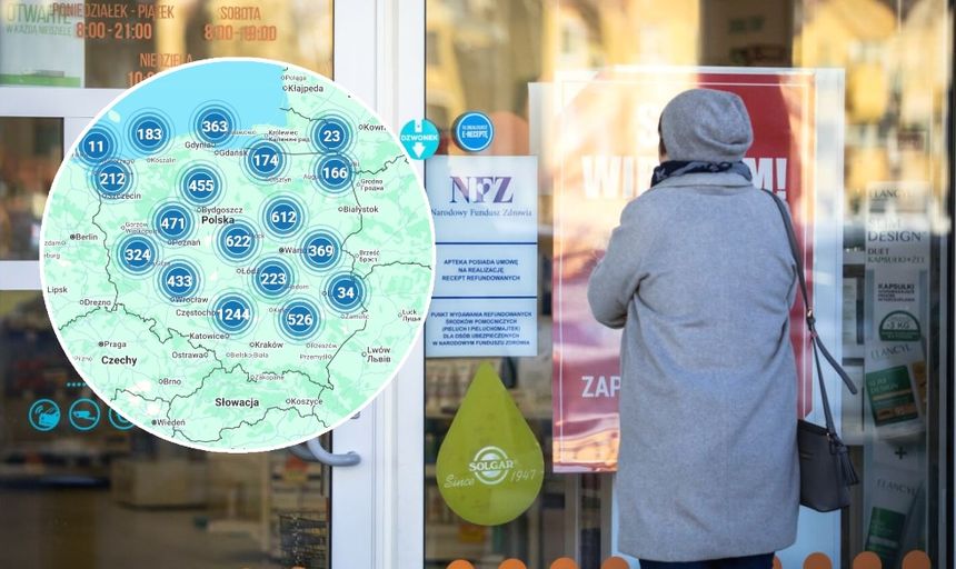 Kobieta w szarym płaszczu przy wejściu do placówki NFZ, patrzy na plakat informacyjny.