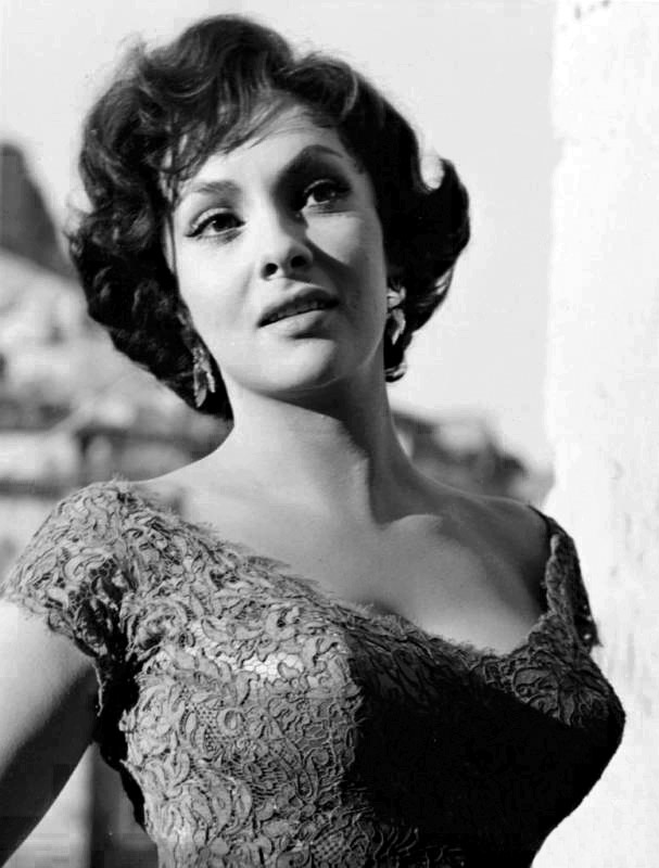 Gina Lollobrigida. Kobieta w eleganckiej, koronkowej sukni, patrząca w dal z delikatnym uśmiechem.