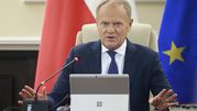 Na zdjęciu Donald Tusk przemawia podczas spotkania, z rękami uniesionymi przed sobą.