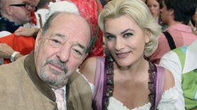 Na zdjęciu uśmiechnięty mężczyzna i kobieta w tradycyjnych strojach, w tle ludzie podczas wydarzenia.