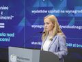 Na zdjęciu kobieta przy mównicy z napisem 