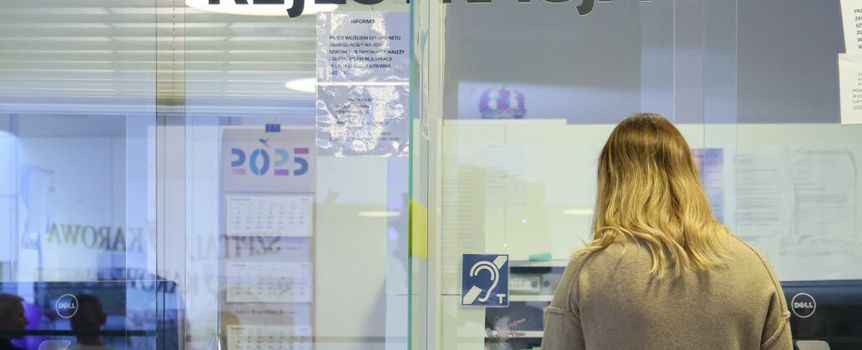 Na zdjęciu widoczna jest osoba w recepcji, z napisem 