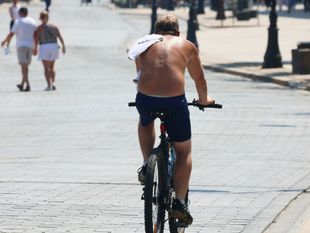 Mężczyzna bez koszulki na rowerze - materiał poglądowy