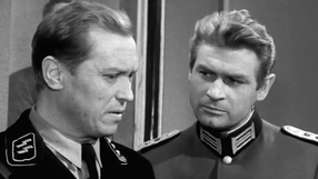 Na zdjęciu dwóch mężczyzn w mundurach wojskowych, jeden w uniformie SS, z poważnymi minami.