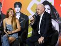Na zdjęciu Shakira rozmawia z mężczyzną w garniturze podczas konferencji prasowej.
