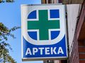 Znak apteki: zielony krzyż na niebieskim tle z napisem 