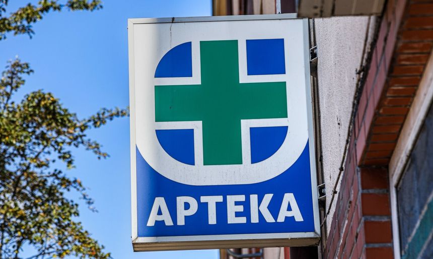 Znak apteki: zielony krzyż na niebieskim tle z napisem 