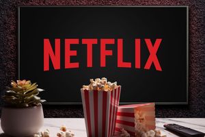 Na ekranie widać logo Netflixa, obok miski popcornu i pilota do telewizora.