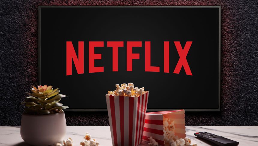 Na ekranie widać logo Netflixa, obok miski popcornu i pilota do telewizora.