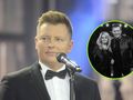 Rafał Brzozowski w garniturze z mikrofonem, na tle sceny.