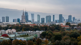 Widok na Warszawę z nowoczesnym skyline'em, w tle Pałac Kultury i Nauki, jesienny krajobraz.