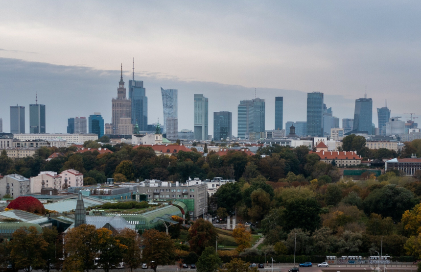 Widok na Warszawę z nowoczesnym skyline'em, w tle Pałac Kultury i Nauki, jesienny krajobraz.