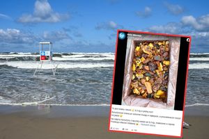Opis ALT: Plaża z falami, w tle wieża ratunkowa, na pierwszym planie zdjęcie bursztynów w skrzynce.