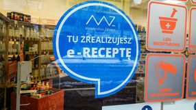 Na szybie apteki widoczny niebieski okrąg z białym napisem 