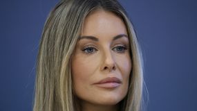 Na zdjęciu: Małgorzata Rozenek-Majdan z długimi, jasnymi włosami, patrząca w dal na tle niebieskiej ściany.