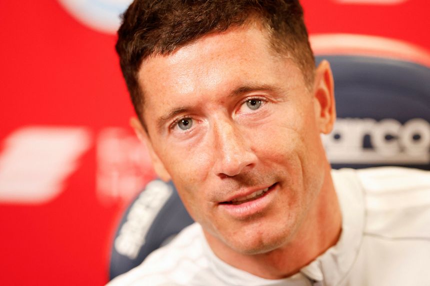 Na zdjęciu Robert Lewandowski, uśmiechający się na tle czerwonej ściany.