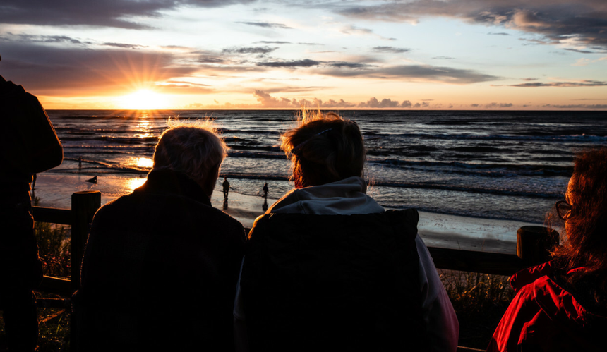 Turyści na plaży w Lubiatowie podczas zachodu słońca