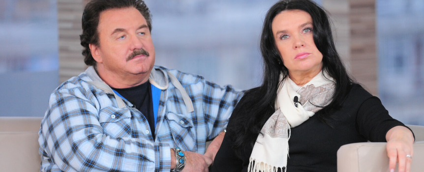 Dwoje ludzi na sofie w studiu telewizyjnym, mężczyzna w koszuli w kratę, kobieta w czerni.