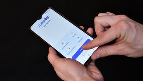 Na zdjęciu widać rękę trzymającą telefon z aplikacją Moje IKP. Wyświetla ekran logowania.