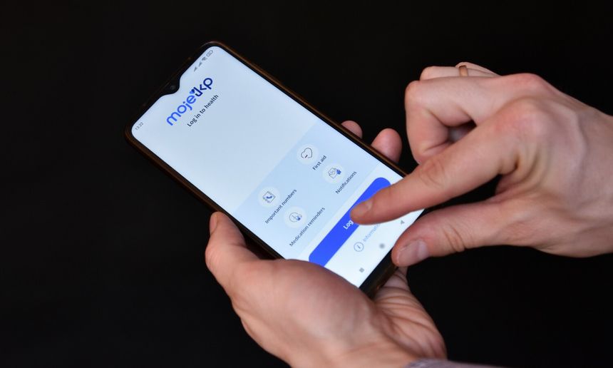 Na zdjęciu widać rękę trzymającą telefon z aplikacją Moje IKP. Wyświetla ekran logowania.