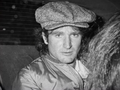 Robin Williams. Na zdjęciu mężczyzna w czapce z dzianiny, siedzący w samochodzie, wygląda na zamyślonego.