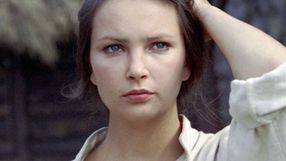 Na zdjęciu młoda kobieta z długimi włosami, w bluzce, o intensywnym spojrzeniu.
