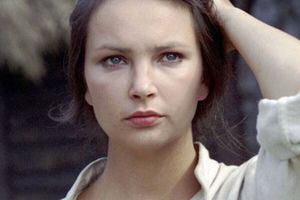 Na zdjęciu młoda kobieta z długimi włosami, w bluzce, o intensywnym spojrzeniu.
