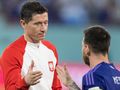 Na zdjęciu Robert Lewandowski w białej bluzie z czerwonymi akcentami, rozmawia z Lionelem Messim.