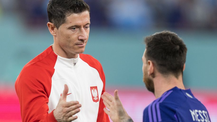 Na zdjęciu Robert Lewandowski w białej bluzie z czerwonymi akcentami, rozmawia z Lionelem Messim.