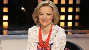 Kobieta z krótkimi, blond włosami, uśmiecha się i nosi kolorową biżuterię.