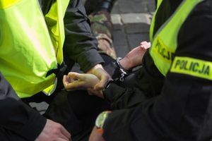 Policjant zakłada kajdanki.