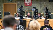 Sala sądowa, otoczona kamerami i dziennikarzami.
